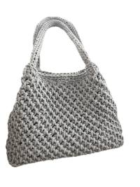 a grey crocheted bag on a black background