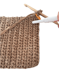 a person is using a crochet hook to make a blanket