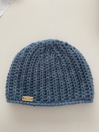 a blue knitted beanie on a table