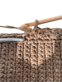 a close up of a crochet stitch with a knitting needle