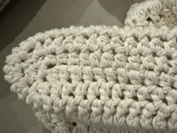 a close up of a white crocheted bag