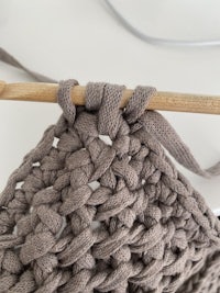 a crocheted bag with a wooden stick attached to it