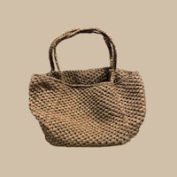 a beige woven tote bag on a beige background